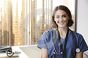 Portrait Of Smiling Female Doctor Wearing Scrubs With Stethoscope In Hospital Office