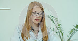 Portrait Of Smiling Female Doctor Wearing White Coat With Stethoscope In Hospital Office.