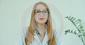 Portrait Of Smiling Female Doctor Wearing White Coat With Stethoscope In Hospital Office.