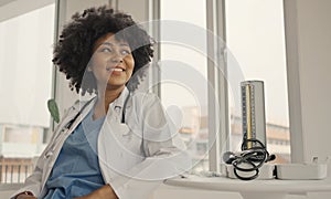 Portrait of a smiling female doctor wearing a white coat with a stethoscope in a hospital office