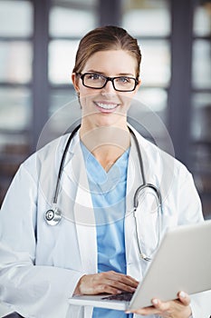 Portrait of smiling female doctor working on laptop