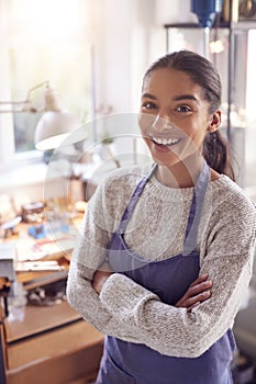 Portrait Of Smiling Female Jeweller At Bench Working In Studio photo