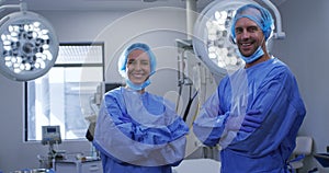 Portrait of smiling female and male caucasian surgeons with face masks and protective clothing