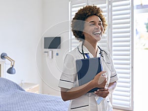 Portrait Of Smiling Female Nurse Wearing Uniform With Digital Tablet In Private Hospital Room