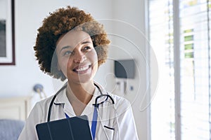 Portrait Of Smiling Female Nurse Wearing Uniform With Digital Tablet In Private Hospital Room