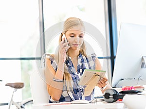 Portrait of smiling female office worker with mobile