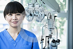 Portrait of smiling female optometrist with eye test equipment