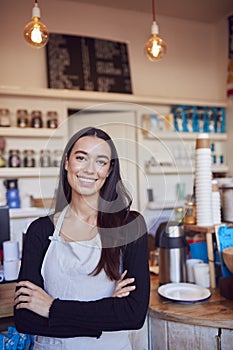 Portrait Of Smiling Female Owner Of Coffee Shop Standing Behind Counter
