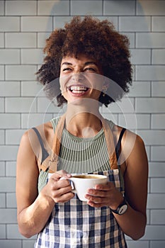 Portrait Of Smiling Female Owner Or Staff Inside Shop Or Cafe Holding Hot Drink