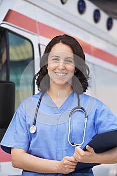 Portrait of smiling female paramedic in front of am ambulance