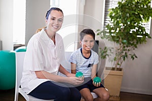 Portrait of smiling female therapist and boy holding stress balls