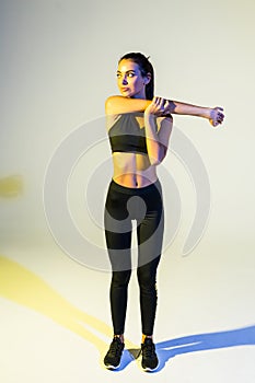 Portrait of a fitness woman stretching her hands isolated over white background