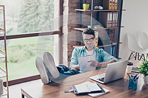 Portrait of smiling freelancer sitting at home in front of computer and writing action plan