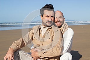 Portrait of smiling gays embracing on beach