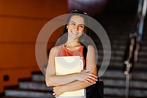 Portrait of a smiling girl with a folder in her hands