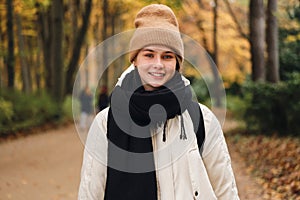 Portrait of smiling girl happily looking in camera in beautiful autumn park