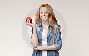 Portrait of smiling girl with healthy teeth holding red apple