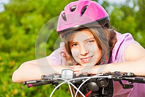 Portrait of smiling girl in helmet on handle-bar
