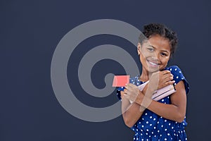 Portrait of smiling girl holding credit card while holding purse