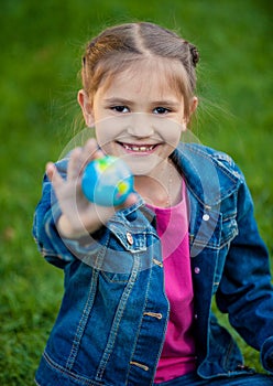 Portrait of smiling girl holding globe in hand