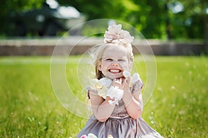 Portrait of smiling girl holding her favourite soft toy in summer day, happy childhood concept