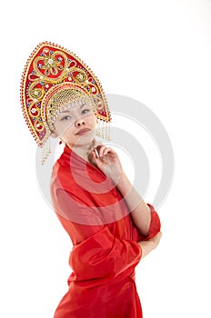 Portrait of smiling girl in kokoshnik & x28;headdress& x29; and red dress on white background.