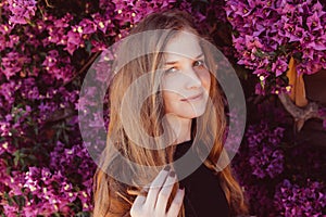 Portrait of smiling girl among purple bougainvillaea