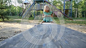 Portrait of smiling girl on the seesaw. Slow motion