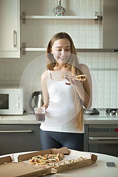 Portrait of smiling girl standing, holding a slice of pizza