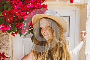 Portrait of smiling girl with tangled hair among purple bougainvillaea