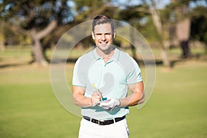 Portrait of smiling golfer with score card