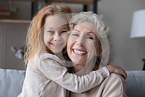 Portrait of smiling grandmother and little granddaughter hugging