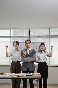 Portrait of smiling group Asian professional confident business people team standing and looking at camera