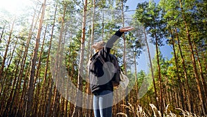 Portrait of smiling happy woman hiking in forest with outstretched hands . Concept of freedom and harmony with nature.