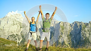 PORTRAIT: Smiling hiker couple outstretch their arms in celebration of fun hike