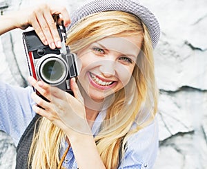 Portrait of smiling hipster girl making photo with retro camera