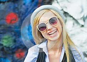 Portrait of smiling hipster girl wearing sunglasses outdoors