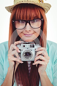 Portrait of a smiling hipster woman holding retro camera