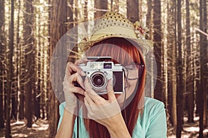 Portrait of a smiling hipster woman holding retro camera