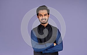 Portrait of smiling Indian guy crossing his arms on lilac background