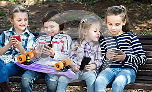 Portrait of smiling kids playing with phones