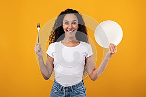 Portrait of Smiling Latin Lady Holding Fork And Plate