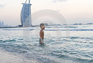 Portrait smiling little baby boy playing in the sea, ocean. Positive human emotions, feelings, joy. Funny cute child making vacati