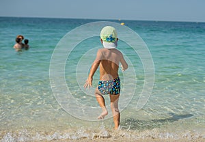 Portrait smiling little baby boy playing in the sea, ocean. Positive human emotions, feelings, joy. Funny cute child making vacati