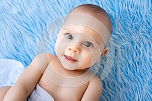 Portrait of a smiling little child boy on a blue fur background