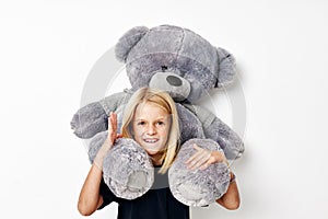 Portrait of a smiling little cutie with teddy bear a toy posing studio