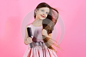 Portrait of smiling little girl brushing her hair