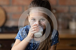 Portrait of smiling little girl drink milk from glass