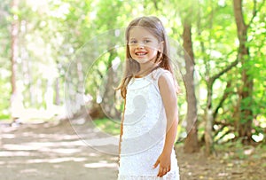 Portrait of smiling little girl walking in the forest