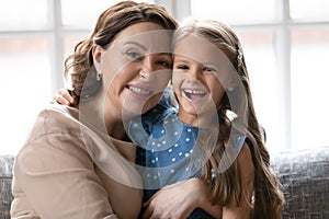 Portrait of smiling mature woman posing with little granddaughter photo